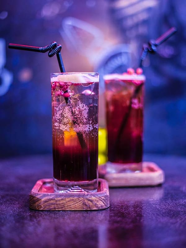 Tall glasses of freshly pressed fruit juice with straws